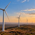 NLC India Renewables: wind turbines on a hilly landscape at sunset
